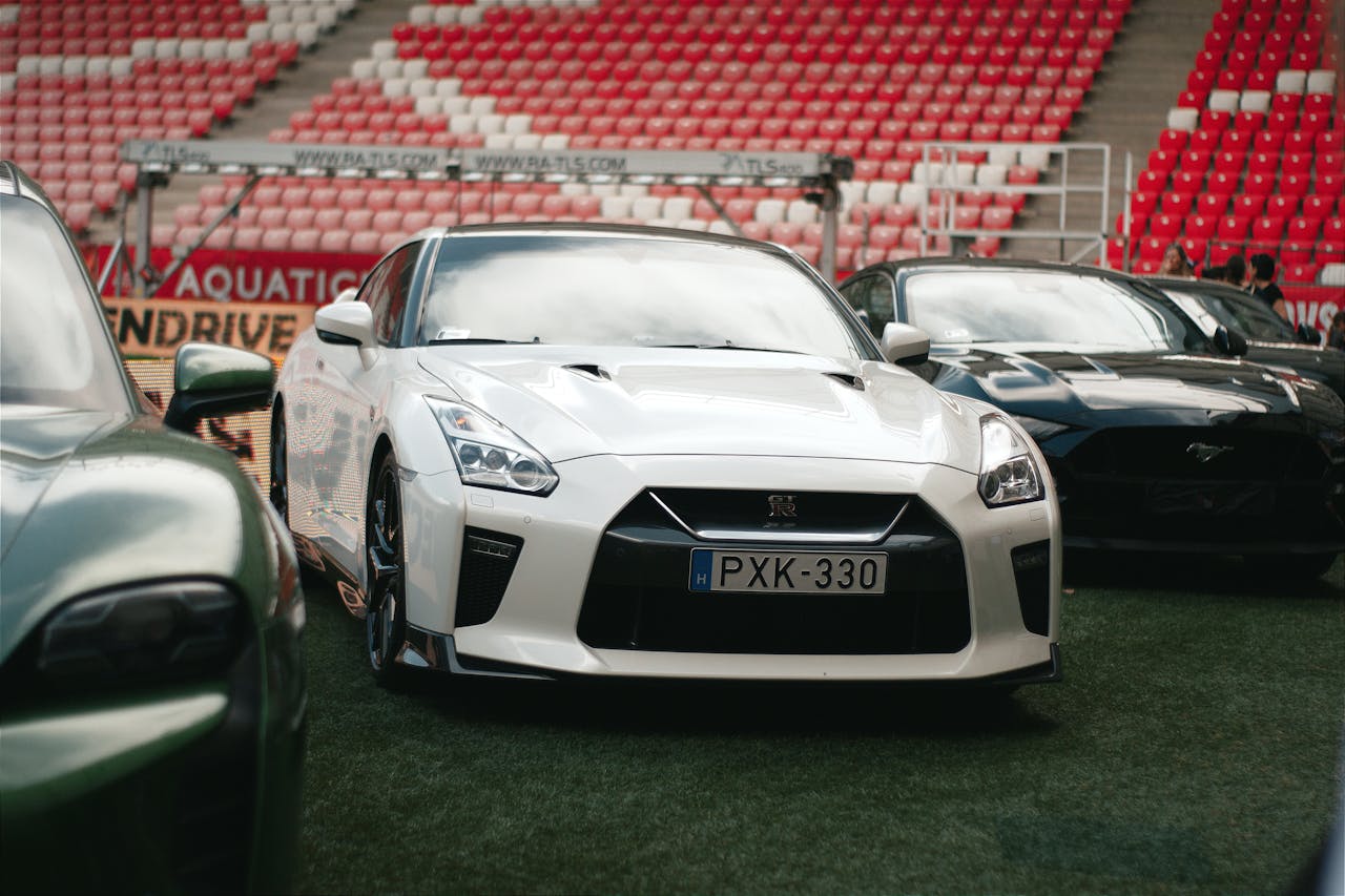 Showcase of high-performance sports cars including Nissan GT-R and Ford Mustang in a Hungarian stadium.